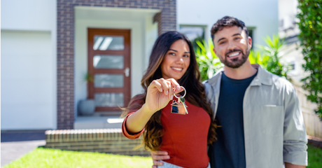 A couple happy in front of a house they just brought - social
